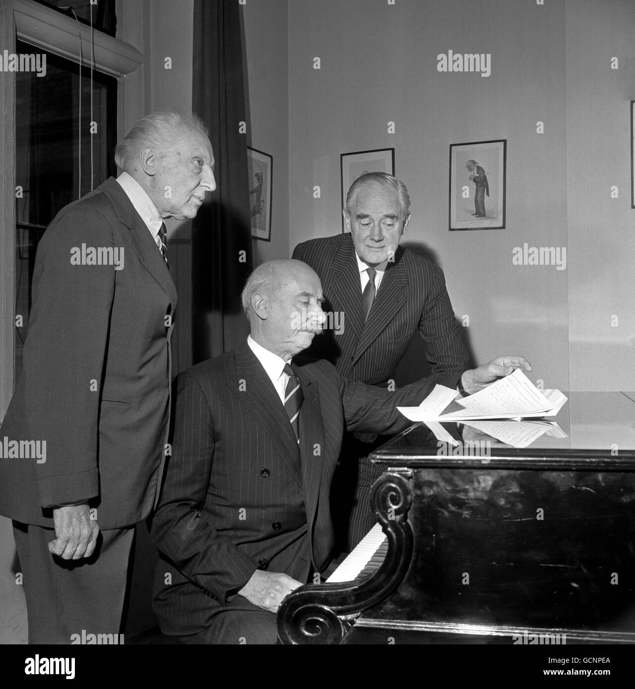 Leopold Stokowski, the conductor, left, discusses his forthcoming concert with Sir Adrian Boult, seated, and Keith Falkner, Director of the Royal College of Music. Stock Photo