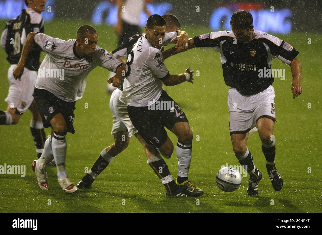 Fulham Clint Dempsey (centre) is helped by team mate Bobby Zamora as he battles for the ball with Port Vale's Lee Collins Stock Photo