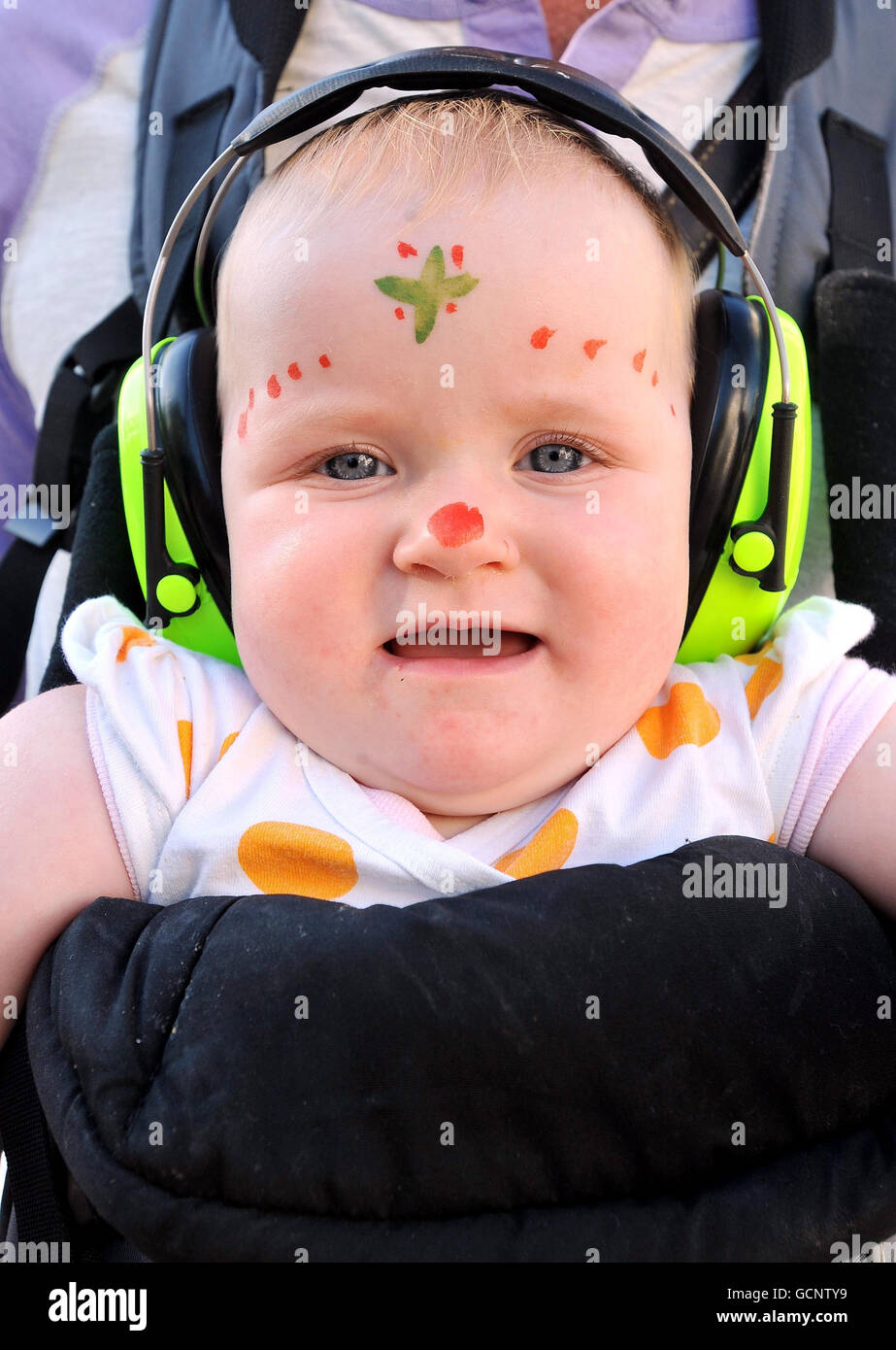 Bella Priestley, 9-months-old, wears ear defenders to protect her from the loud music during the Notting Hill Carnival, west London. Stock Photo