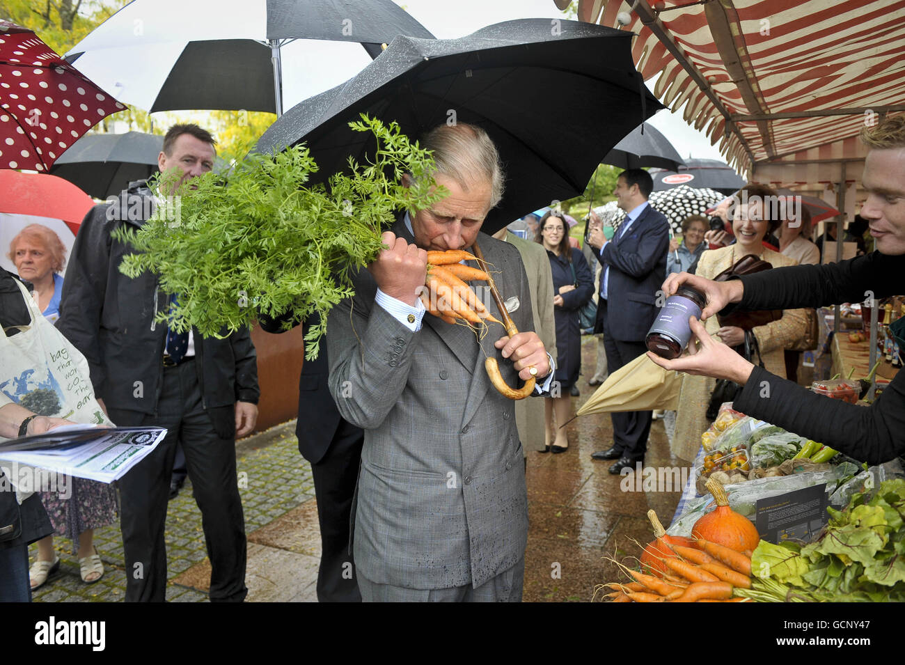 The Prince of Wales receives and sniffs a bunch of carrots from a stall holder at the National Botanic Gardens of Wales in Carmarthen as he continues his tour of Britain to promote his sustainable living initiative START. Stock Photo