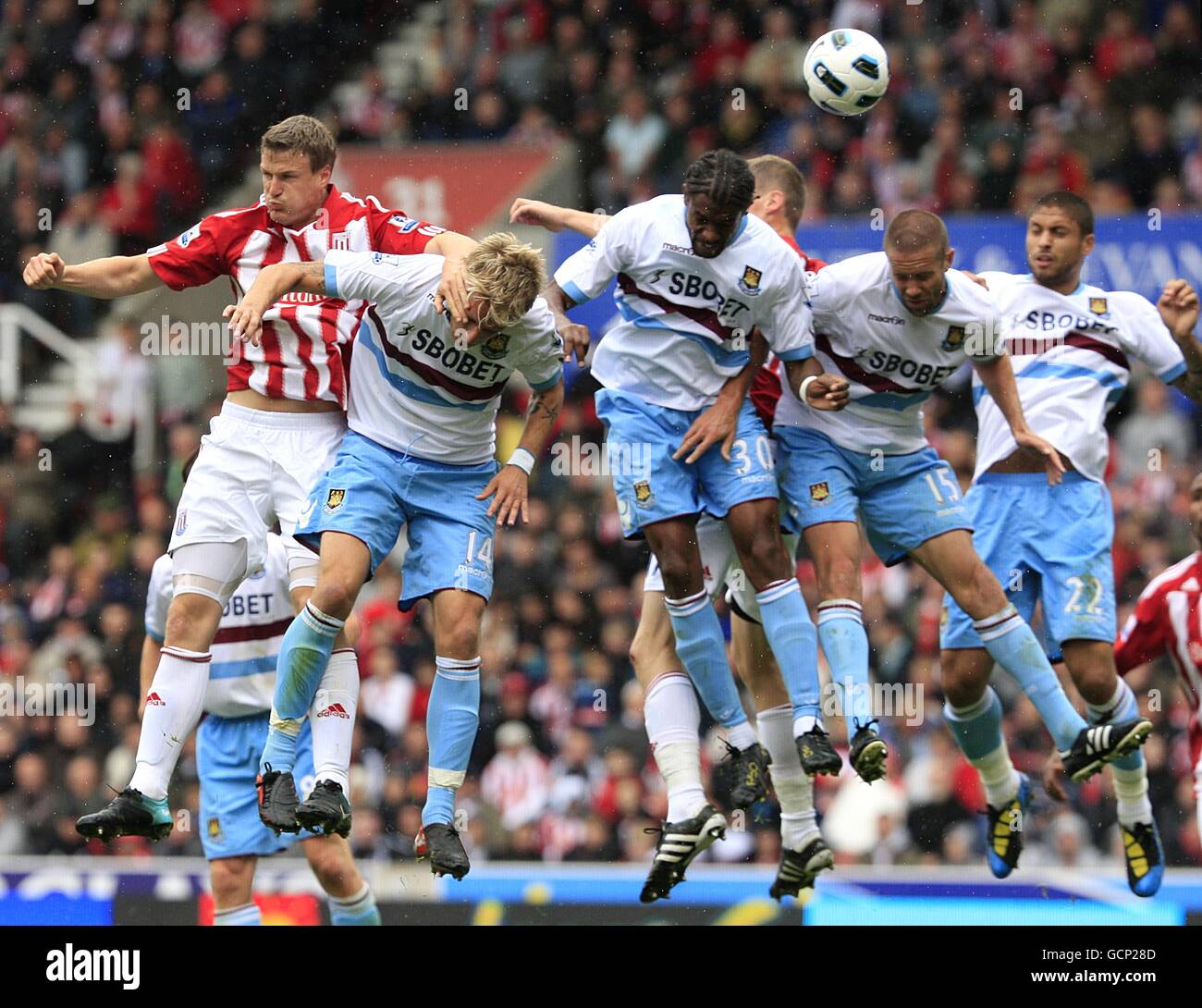 Soccer - Barclays Premier League - Stoke City v West Ham United - Britannia Stadium. Stoke City's Robert Huth (left) jumps highest to flick the ball on Stock Photo