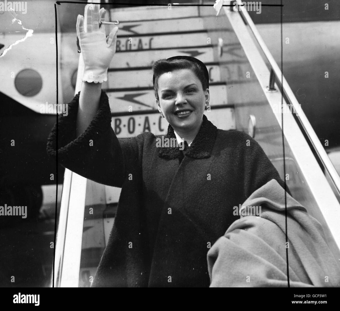 Star of Hollywood musical films Judy Garland is on a variety tour of Britain. It keeps her busy, but not too busy to make flying trips. Here she is in Dark, drape-style coat with tiny close-to-the-skull hat-- as she arrives at London Airport to B.O.A.C. from prestwick, Scotland. Later she leaves for Paris, but will be back in time to celebrate her birthday. She opens in Manchester on June 7th 1951 Stock Photo