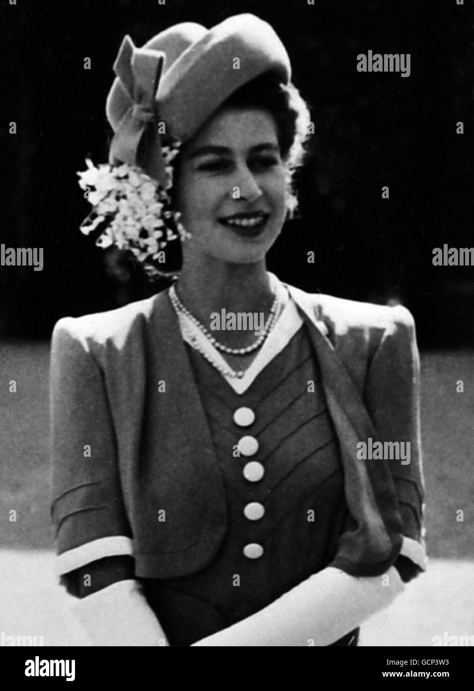 Princess Elizabeth at Drumhead service H.R.H Princess Elizabeth, Colonel of the Grenadier Guards, attended a drumhead service outside the Guards Chapel at Wellington Barracks. Afterwards the princess took the salute at Buckingham Palace when members of the Grenadier Guards commandes Association marched past. Picture shows: Princess Elizabeth wore this charming summer ensemble for the service. The frock, in mustard-coloured light woollen material, has a concertinapleated skirt and short bolero jacket. The felt tilted hat is decorated with lilies of the valley and the dress is edged in white Stock Photo