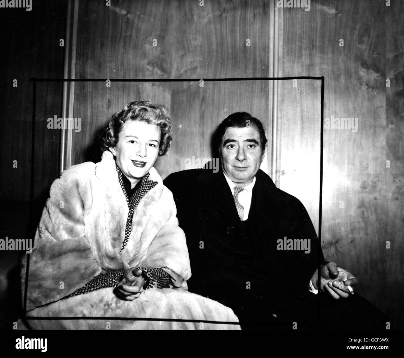 Airport Parting Film actor Robert Newton with his American wife, Vera, whom he saw off at London Airport by Pan American Clipper for New York. Mrs. Newton was taking their six months old son, Kim- but he was 'safely tucked away'. Mrs. Newton explained: 'He has a cold and we do not want to disturb him'. Newton expects to join his wife and family in five weeks time. February 27th 1954 Stock Photo