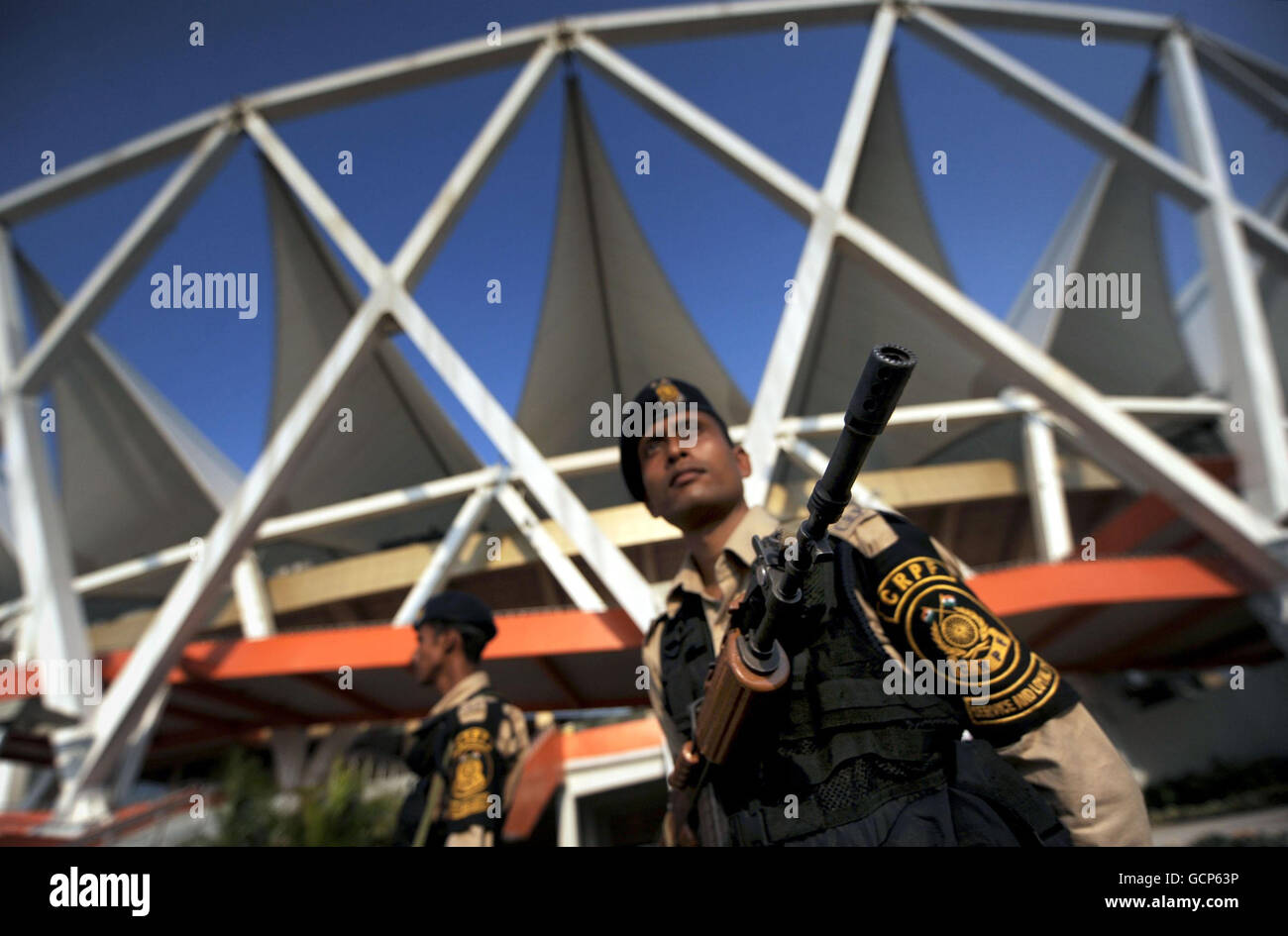 Armed guards patrol the Jawaharlal Nehru Stadium, in New Delhi, India, ahead of the 2010 Commonwealth Games opening ceremony. Stock Photo
