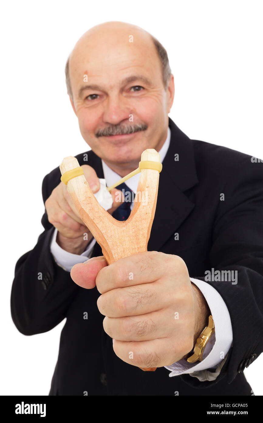 Elderly businessman in a suit shooting slingshot with crumpled paper