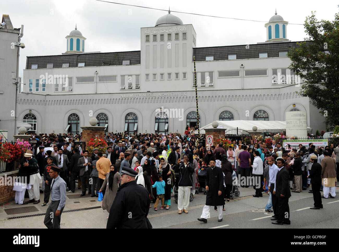 Ahmadi muslims depart the Baitul Futuh Mosque in Morden, London, the largest mosque in Western Europe, after celebrating Eid with prayer, at which over 10,000 worshippers received a live Eid sermon by the worldwide head of the Ahmadiyya Muslim community, His Holiness, Hadhrat Miza Masroor Ahmad. The sermon was telecast live throughout the world and the community also paid its respects to the victims of the 9/11 terrporist attrocities in America on the ninth anniversary of the attacks. Stock Photo