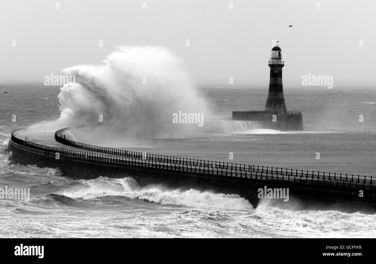RE-TRANSMISSION CHANGING THE NAME OF LIGHTHOUSE TO ROKER LIGHTHOUSE. PLEASE AMEND. NOTE THIS IMAGE HAS BEEN CHANGED TO BLACK AND WHITE. Gale force winds crash waves from the North Sea into the Roker Lighthouse in Sunderland. Stock Photo