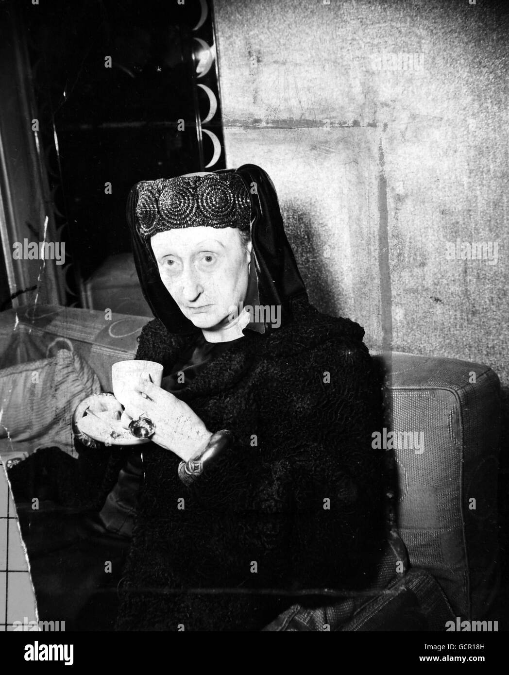 Dr. Edith Sitwell (pictured here), member of the famous literary family, becomes a DBE (Dame of the Order of the British Empire) in the Queen's birthday Honours. Dr. Sitwell, sister of Sir Osbert Sitwell and Sacheverell Sitwell, is an historian, novelist, script writer and poetess. She recently visited Hollywood, where she worked on the film script of 'Fanfare for Elizabeth', her book on Henry VIII and Ann Boleyn. An individualist of uncertain age (she has admitted to 66, 8 and 78). Dr. Sitwell favours Plantagenet style headdress with flowing drapery, ornate rings and bracelets. June 9th 1954 Stock Photo