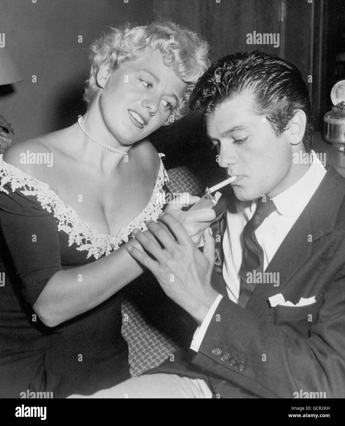 Film - Tony Curtis and Shelley Winters - Los Angeles, USA. American actress Shelley Winters lighting a cigarette for actor Tony Curtis. Stock Photo
