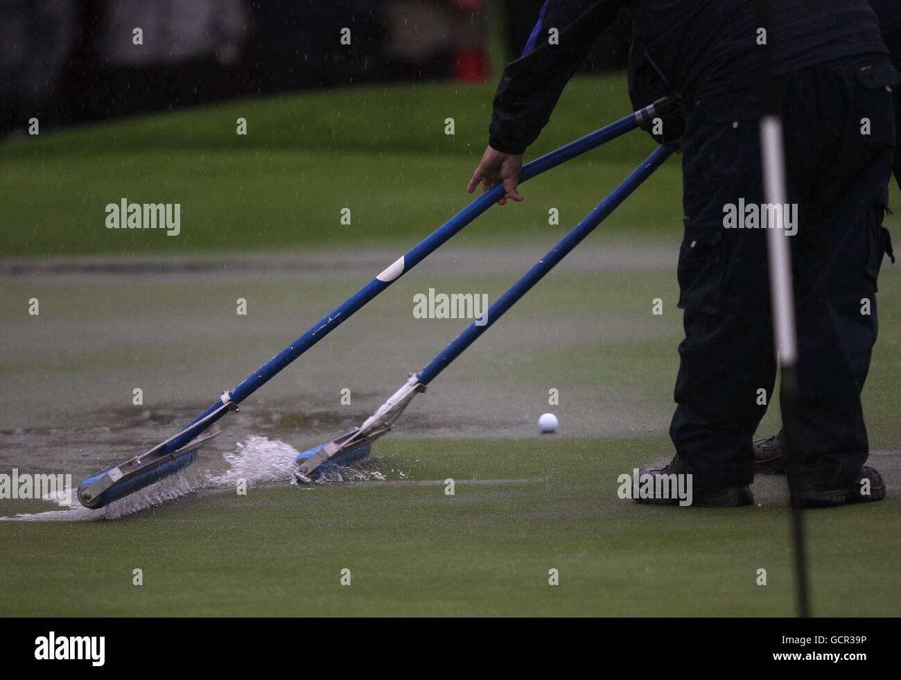 Golf - 38th Ryder Cup - Europe v USA - Day One - Celtic Manor Resort. Stewards clear rainwater from the putting green Stock Photo