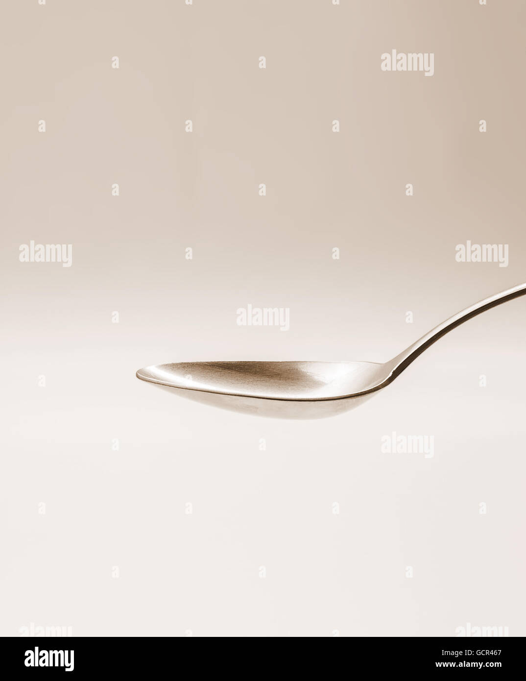 Empty tablespoon of metal on sepia background, horizontal Stock Photo