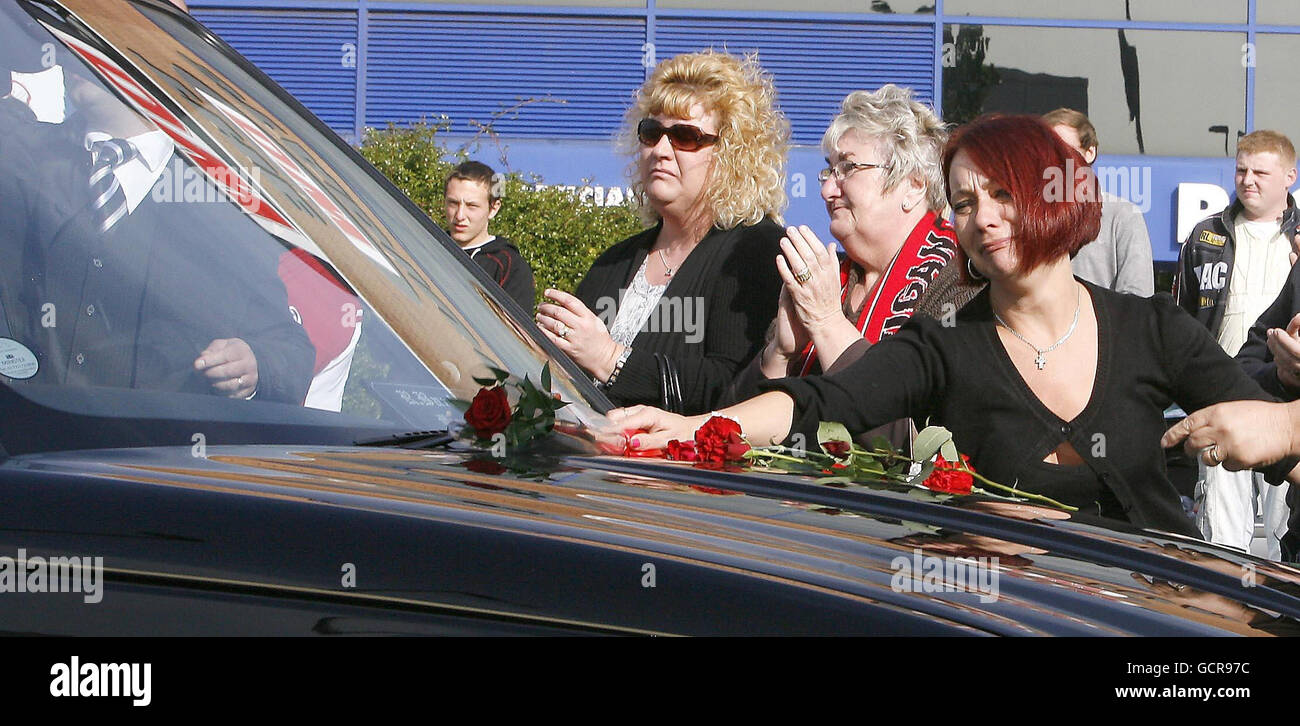 Fan's place roses on the funeral cars during the funeral procession for former England Rugby League star Terry Newton outside the DW Stadium, Wigan. Stock Photo