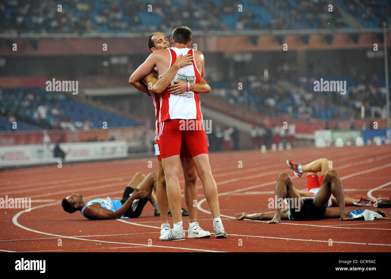 England's Martin Brockman (centre right) celebrates winning the 1500m race  and going to to take over all third in the Decathlon during the Day Five of  the 2010 Commonwealth Games at the