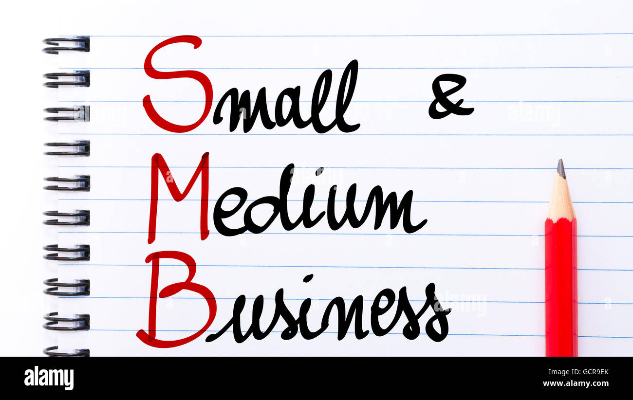 SMB Small and Medium Business written on notebook page with red pencil on the right Stock Photo