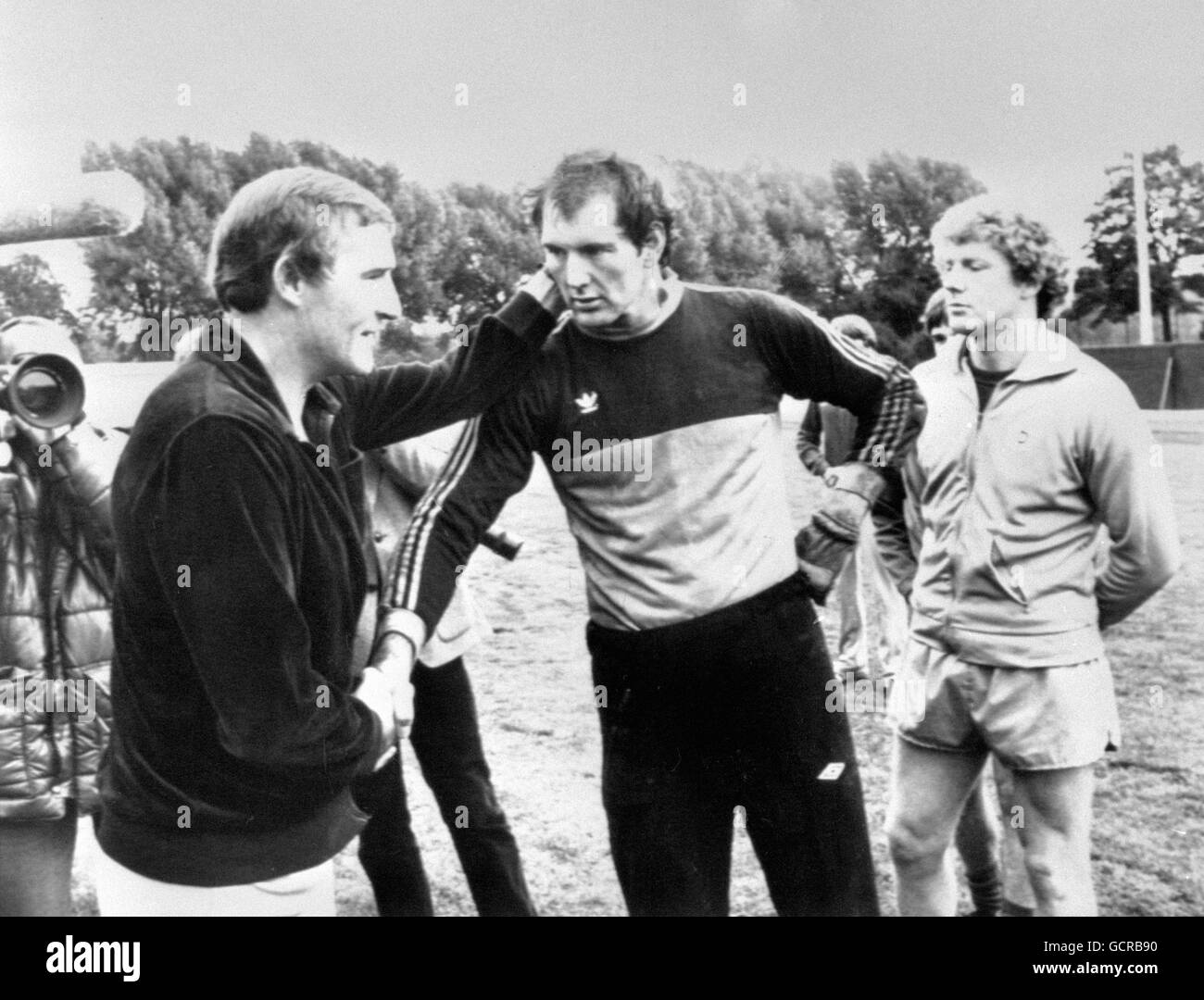 Manager Malcolm Allison, left, says goodbye to the Manchester City team at Maine Road. He shakes hands with Joe Corrigan whilst Keith McRae looks on. Stock Photo