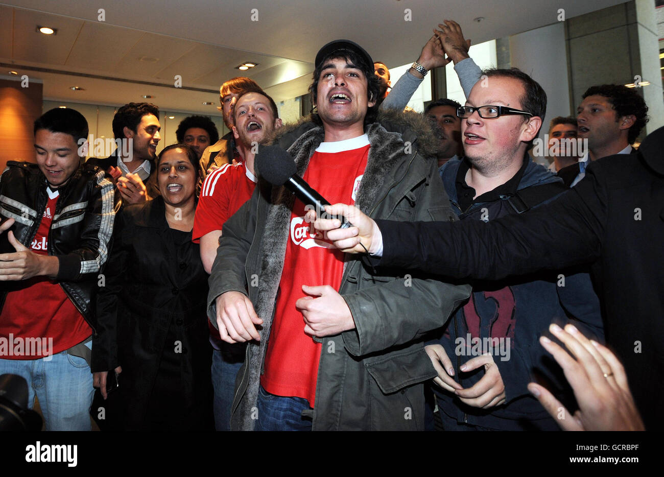 Liverpool FC fans celebrate the news of new owners at the club outside the offices of Slaughter and May in the City of London today. Stock Photo