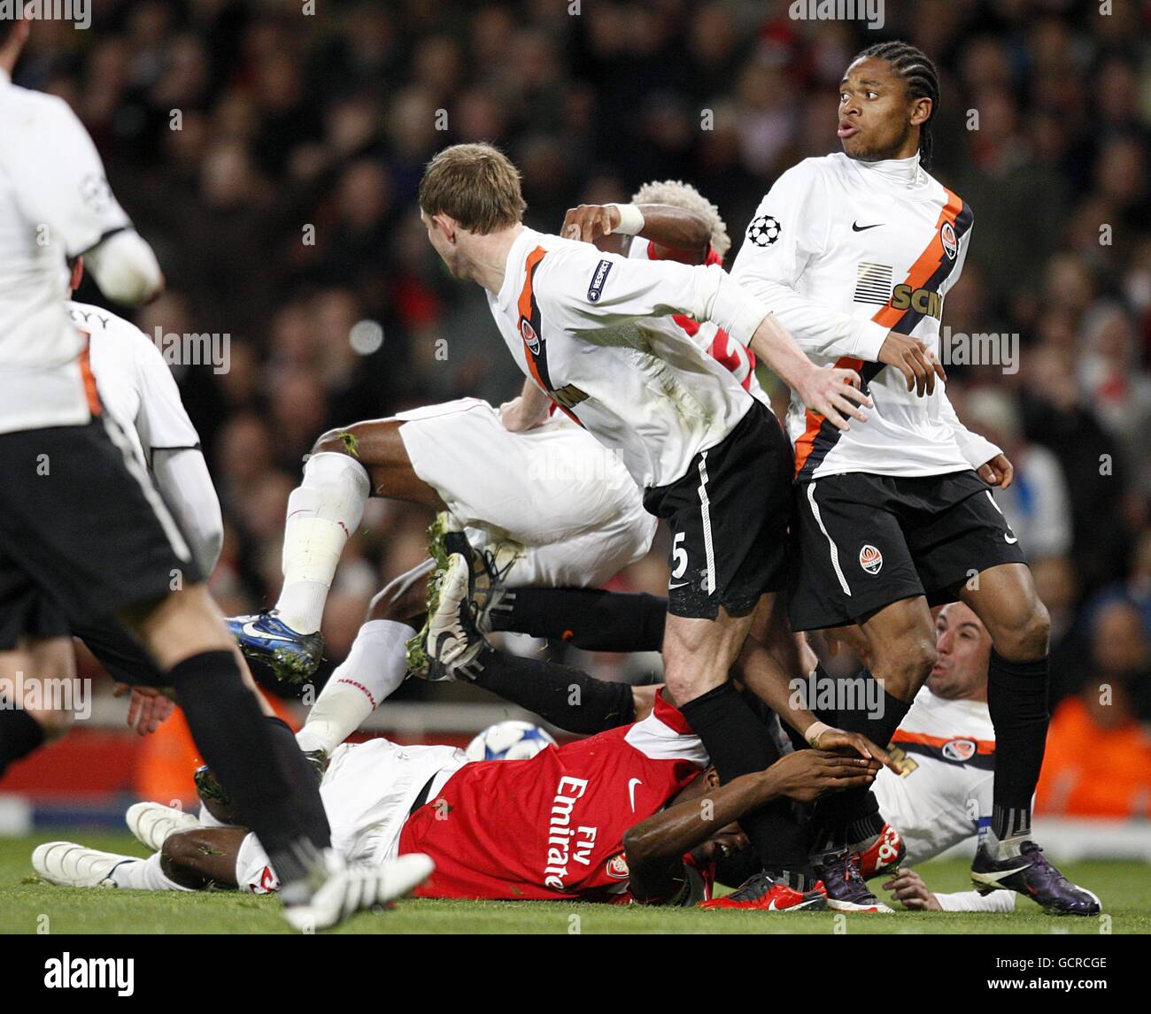 Arsenal's Johan Djourou (floor) is fouled by Shakhtar Donetsk's da Silva Luiz Adriano (right) resulting in a penalty scored by Arsenal's Francesc Fabregas Stock Photo