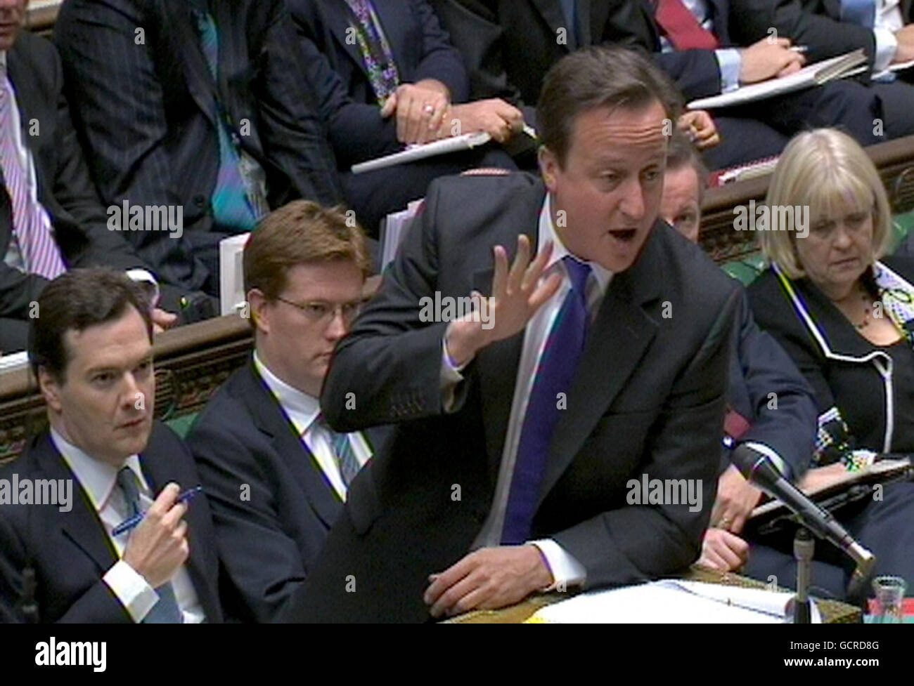 Prime Minister David Cameron speaks as Chancellor George Osborne (left) and Chief Secretary to the Treasury Danny Alexander (second left) look on during Prime Minister's Questions in the House of Commons, London. Stock Photo