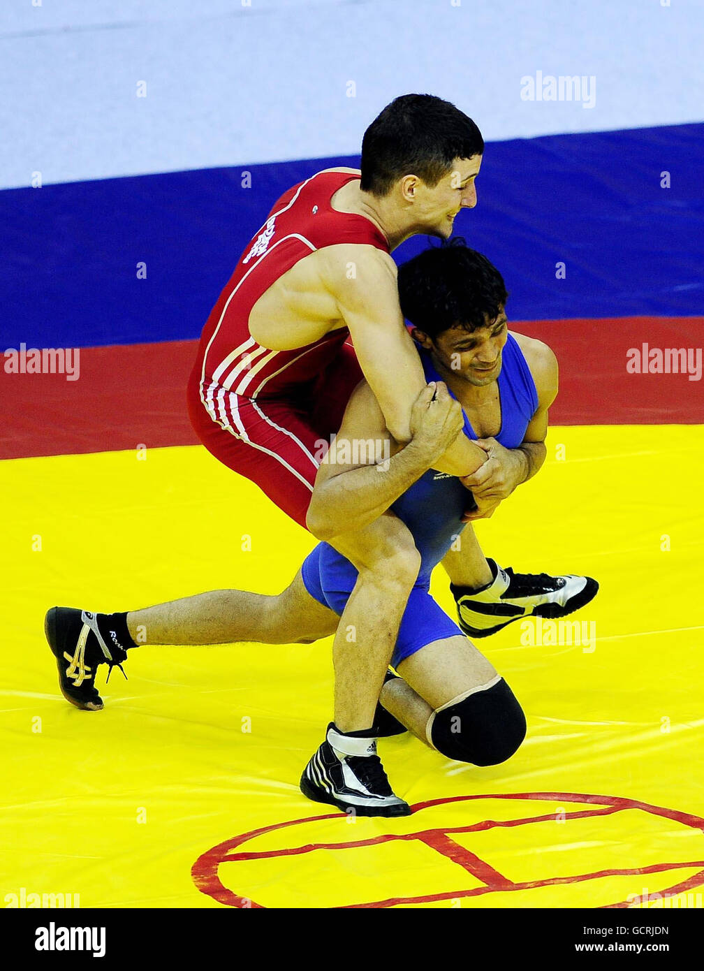 England's Terence Bosson is pulled to the ground by India's Raviwda Singh during the Greco Roman Men 60kg Wrestling Final on Day Two of the 2010 Commonwealth Games at the IG Stadium in Delhi, India. Stock Photo