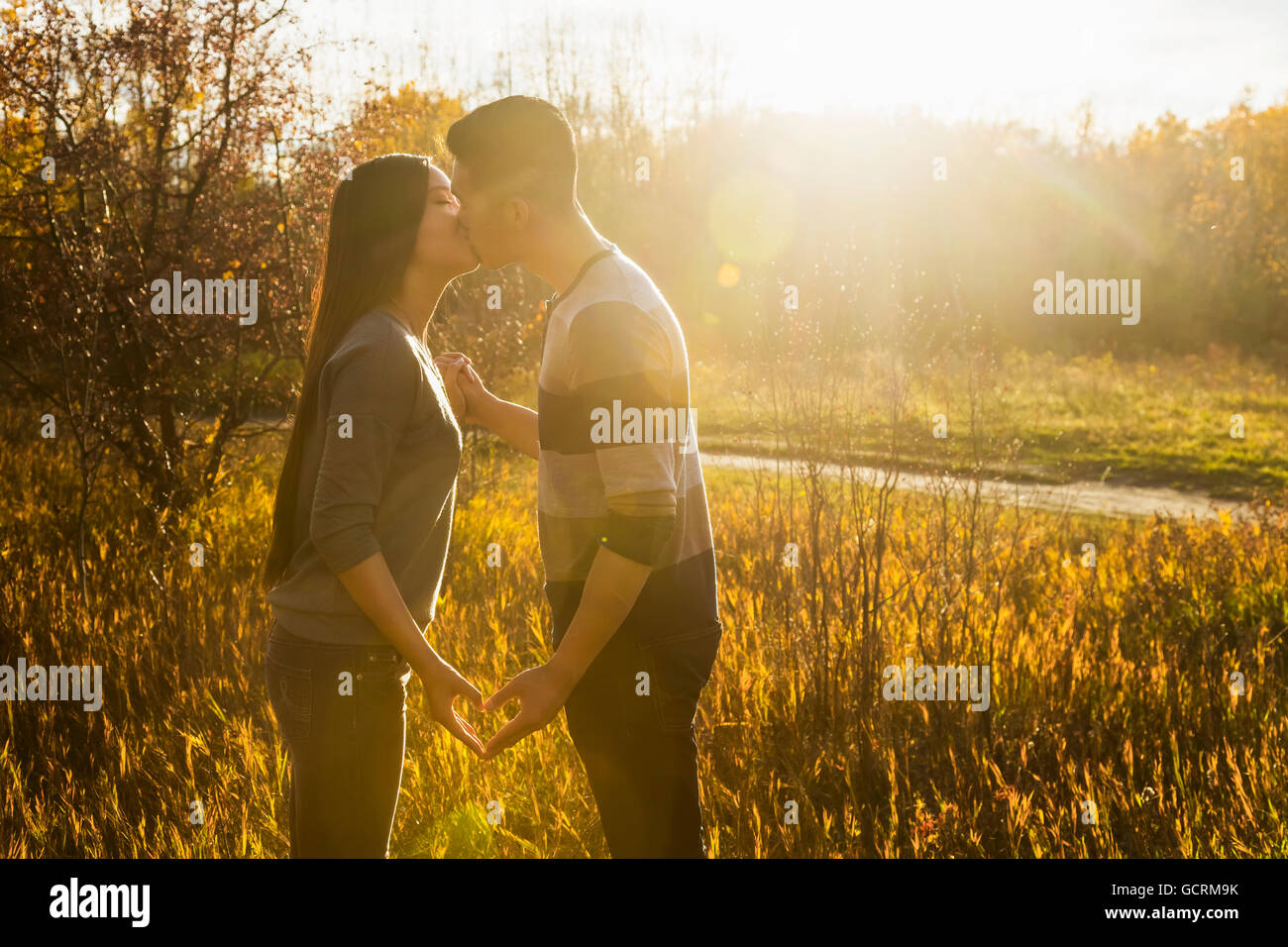 A Young Asian Couple Kissing In A Park In Autumn And Making A Heart
