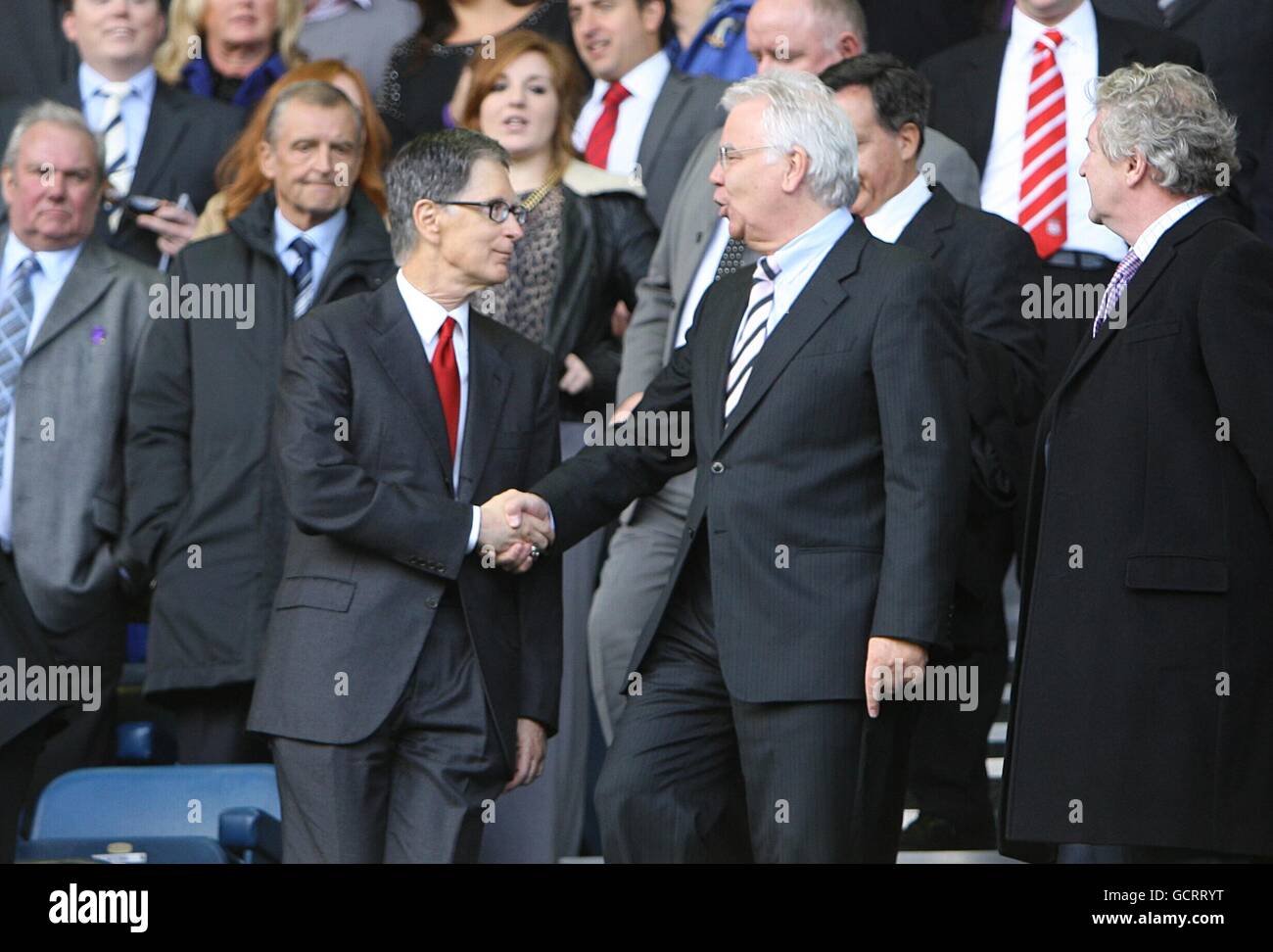 Liverpool FC's new owner John W Henry (left) shakes hands with Everton chairman Bill Kenwright in the stands Stock Photo