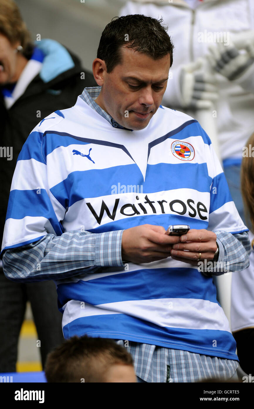 Soccer - npower Football League Championship - Reading v Swansea City - Madejski Stadium. A Reading fan texts on his mobile phone in the stands Stock Photo