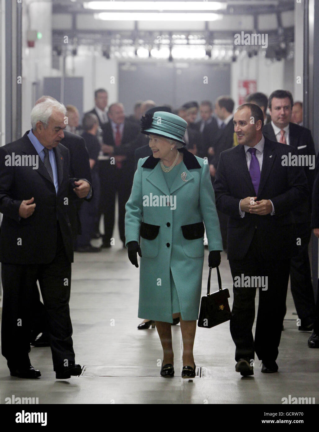 Alan Smith Regional Supply chain Director (left) and George David Chairman of Coca-Cola Hellenic (right) give Queen Elizabeth II a tour around the Coca-Cola bottling plant in Lisburn before she opened the new visitors centre. Stock Photo