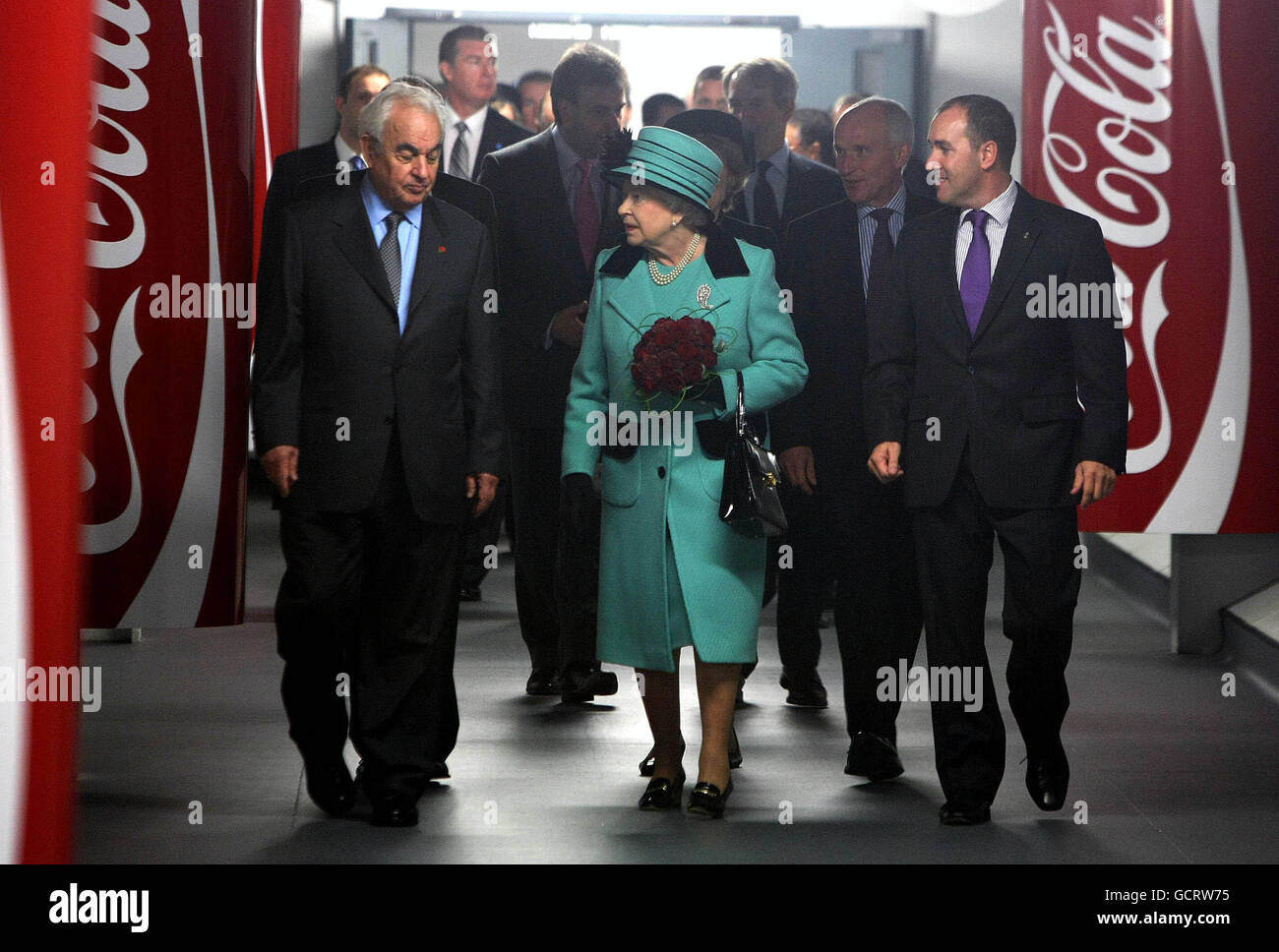 George David Chairman of Coca-Cola Hellenic (left) and Alan Smith Regional Supply chain Director (right) give Queen Elizabeth II a Tour around the Coca-Cola bottling plant in Lisburn before the opening of the new visitors centre. Stock Photo