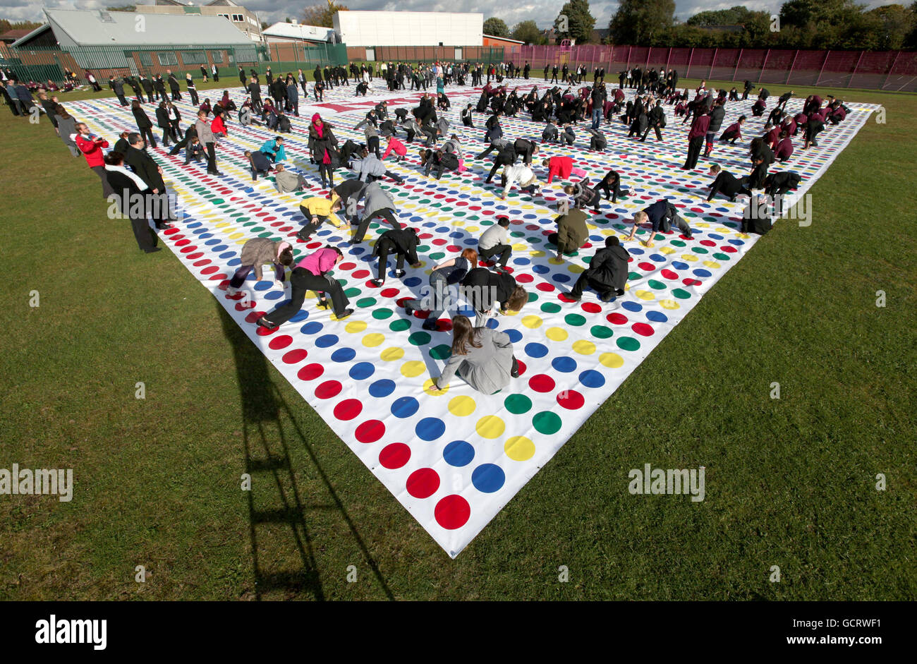 Pupils from Lostock College in Stretford, Manchester, break the current Guinness World Record for largest Twister mat, to celebrate Hasbro Family Game Night, a new initiative to get families playing together. Stock Photo