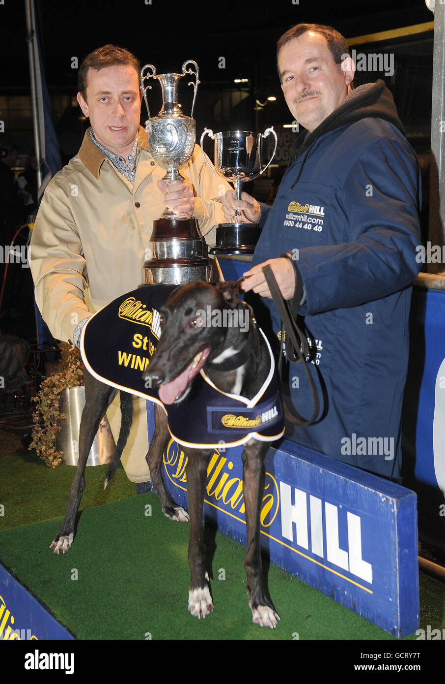 Trainer Paul Donovan (left) and head kennel man Ray Tibos (right) celebrate after Droopys Bradley won the Williamhill.com St Leger Final at Wimbledon Greyhound stadium, London. Stock Photo