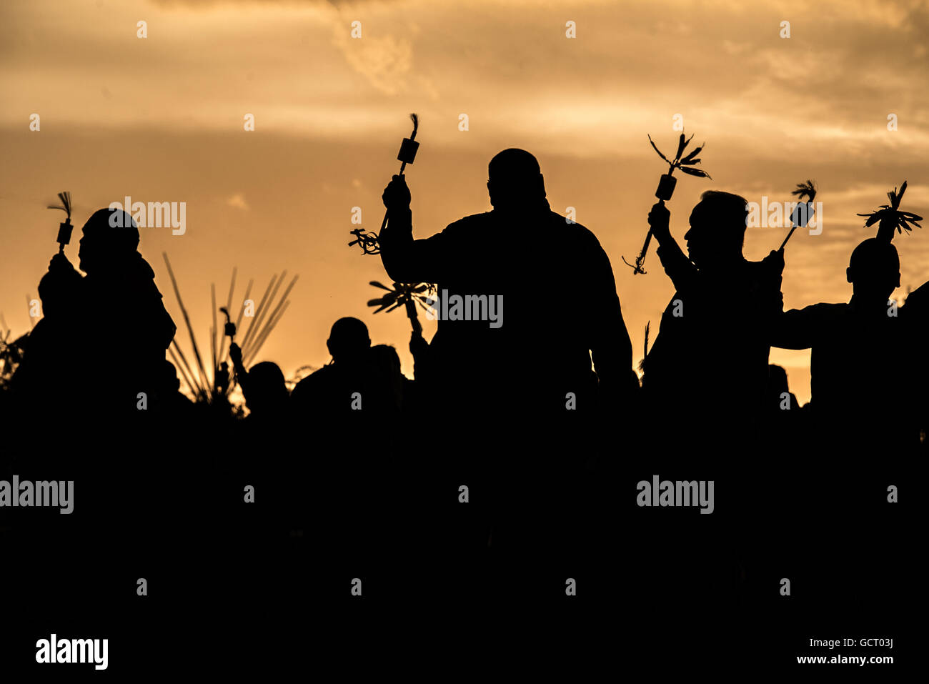 Silhouette of Kiowa gourd dancers at gourd dance powwow in Carnegie