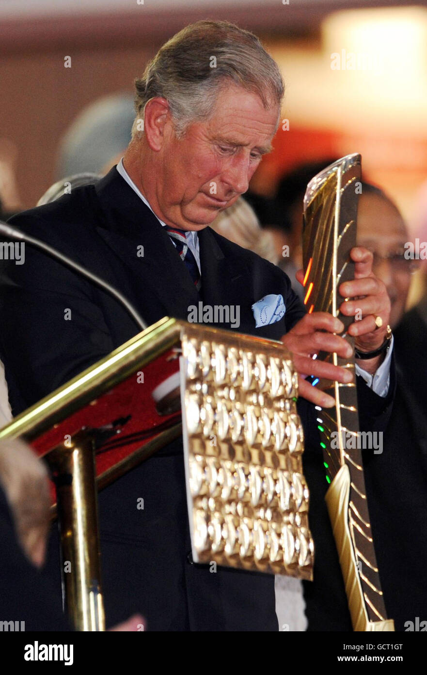 The Prince of Wales receives the Queen's baton and reads a message from Britain's Queen Elizabeth II to announce the opening of the 2010 Commonwealth Games in New Delhi, India. Stock Photo