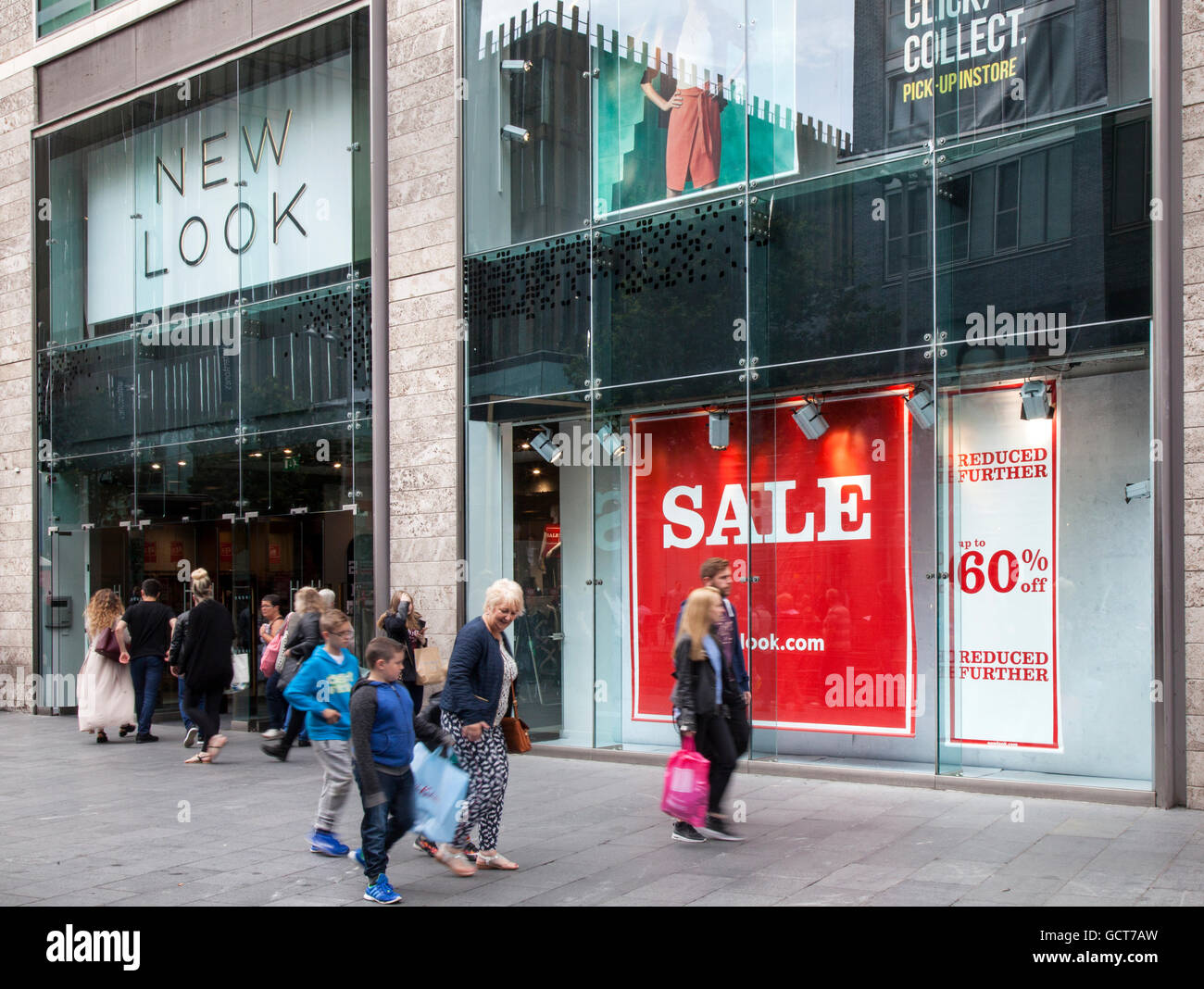 People passing shop windows of business retail fashion stores in the ...