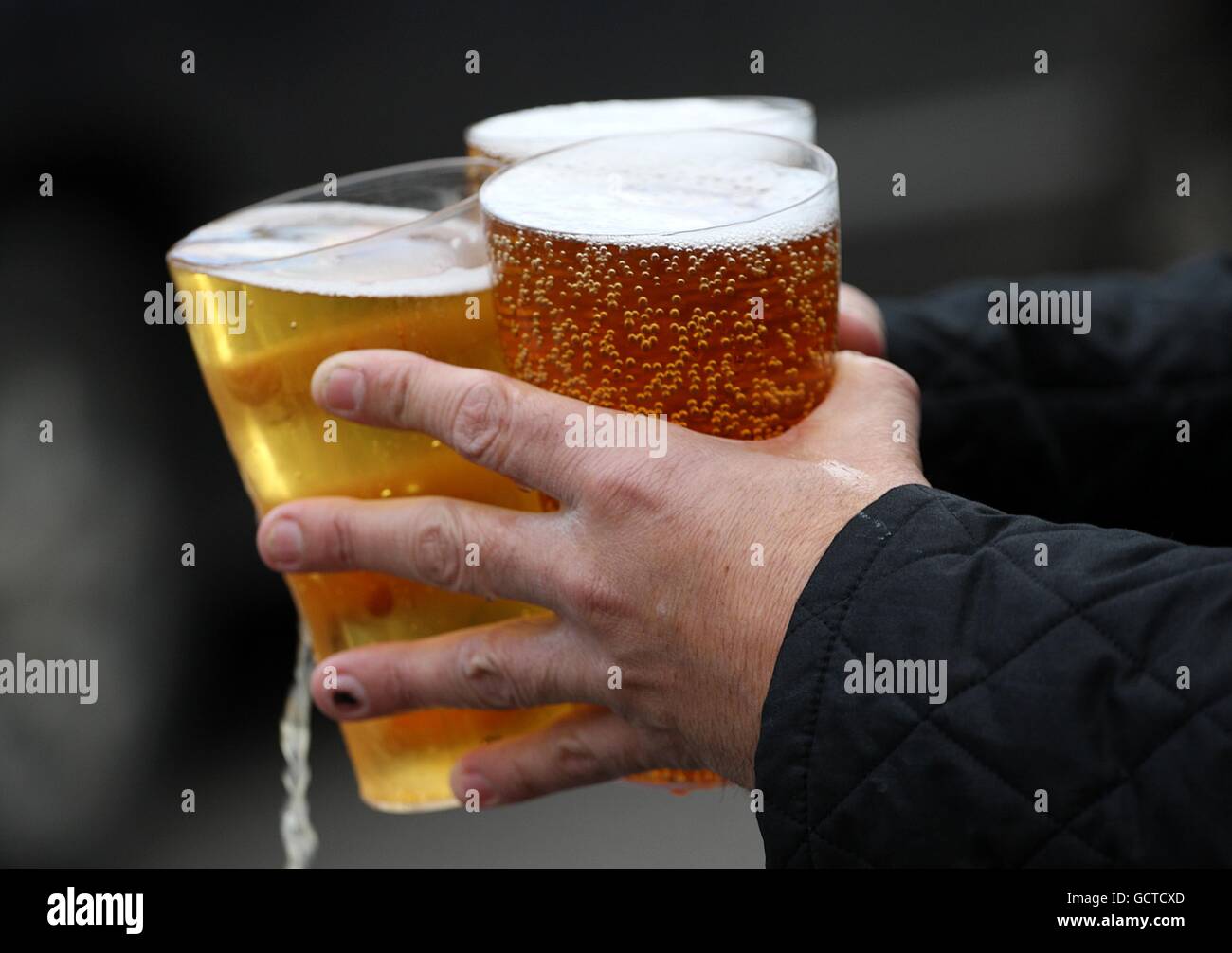 Soccer - npower Football League Championship - Cardiff City v Swansea City - Cardiff City Stadium. A fan carries three pints of alcohol Stock Photo