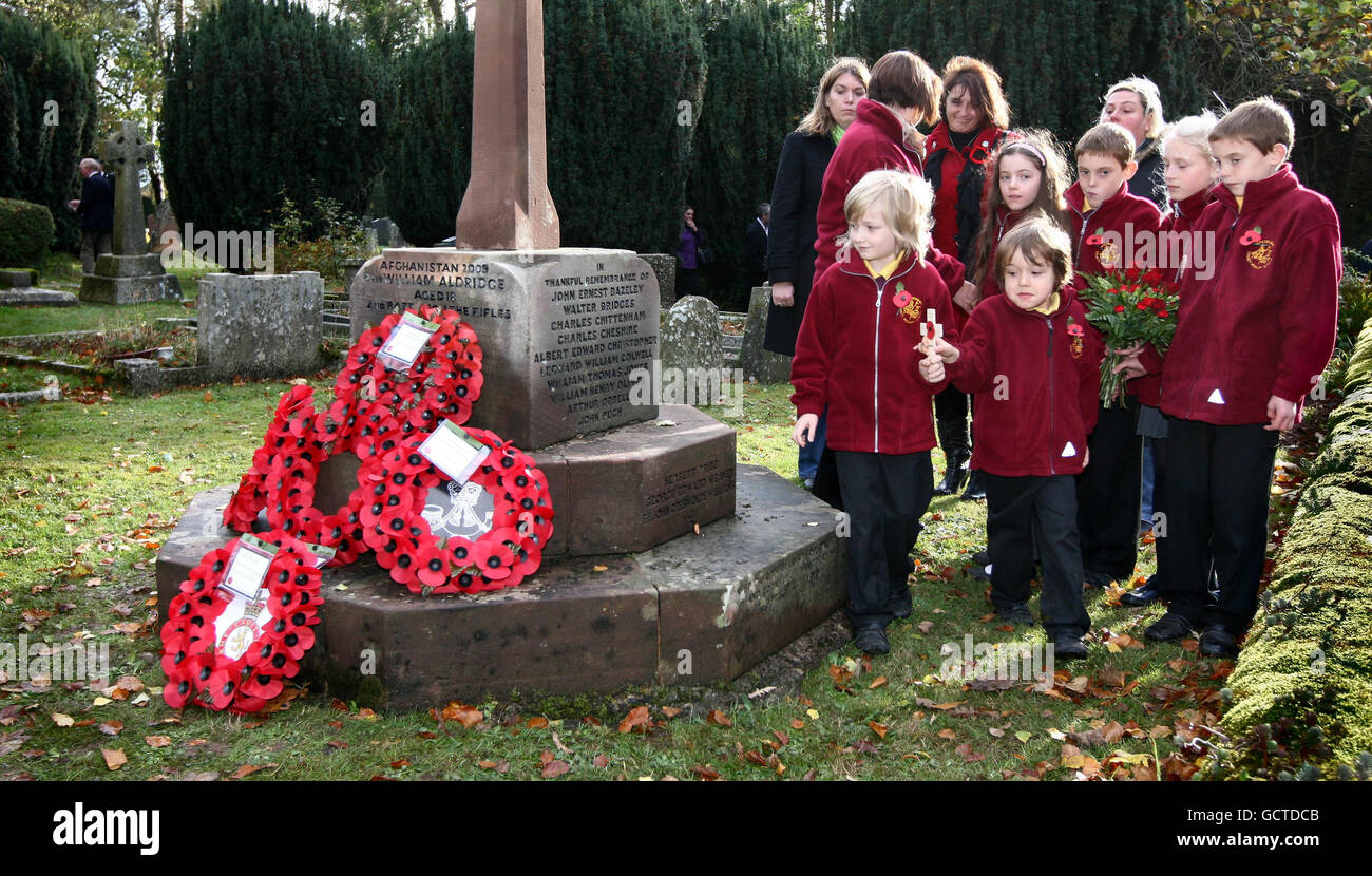 George Aldridge, seven (left) and his brother, Archie, five, watched by school friends from Bredenbury County Primary school, prepare to lay a cross at a memorial to their brother, Rifleman William Aldridge, who was killed, aged 18, in Afghanistan, whose name was added to the village memorial, at a remembrance service and re-dedication of the memorial. Stock Photo