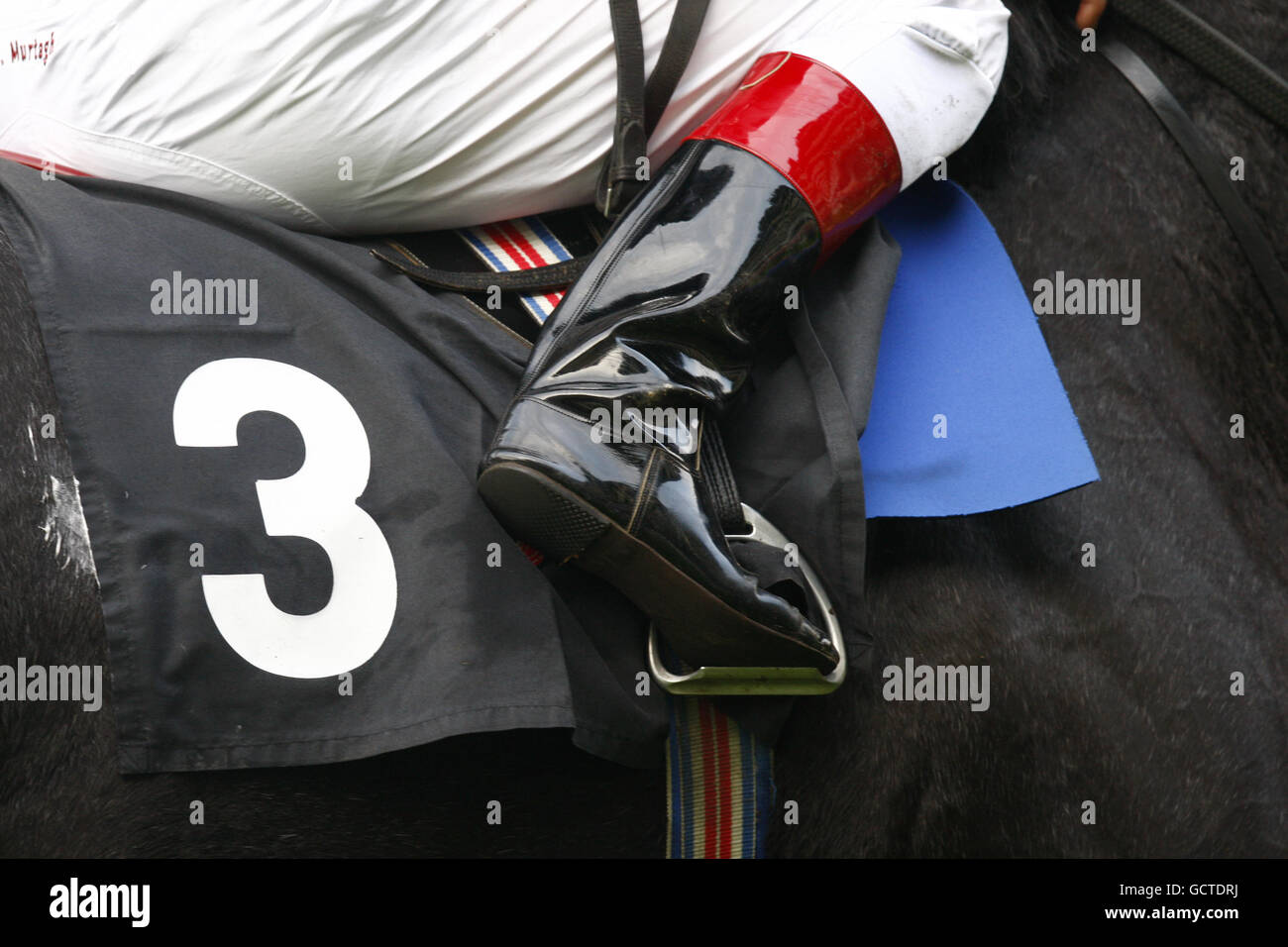 Detail of a jockey's boots and race number on the saddlecloth of his ride Stock Photo