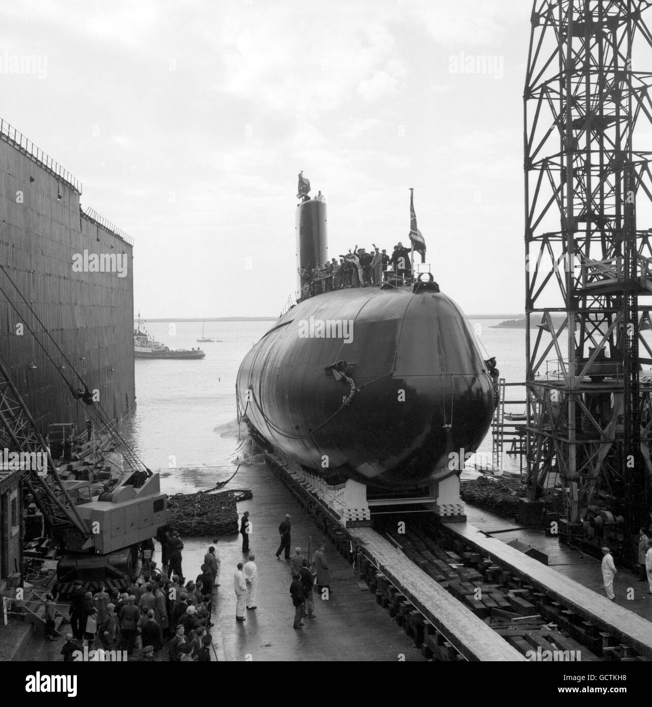 Britain's first nuclear-powered submarine, HMS Dreadnought, slides down the ways into the Walney Channel after her launch by Queen Elizabeth II from the Vickers Armstrong yard in Barrow-in-Furness, Lancashire. Stock Photo