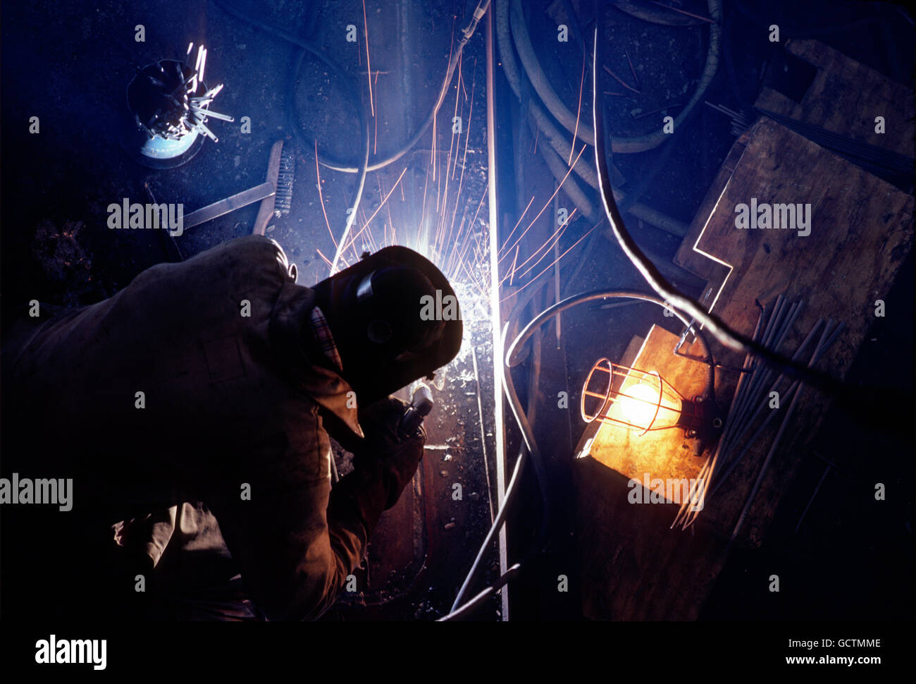 Overhead view of welder working to refurbish a navy ship; Naval Yard; Philadelphia; Pennsylvania; USA Stock Photo