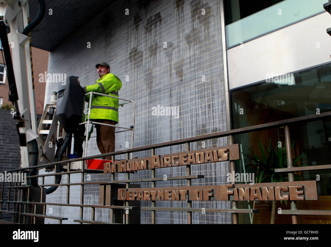 Workmen clean the egg splattered front of the Department of Finance after yesterday's protest in central Dublin today as the Government's planned package of spending cuts and tax hikes for the year ahead will be unveiled later. Stock Photo