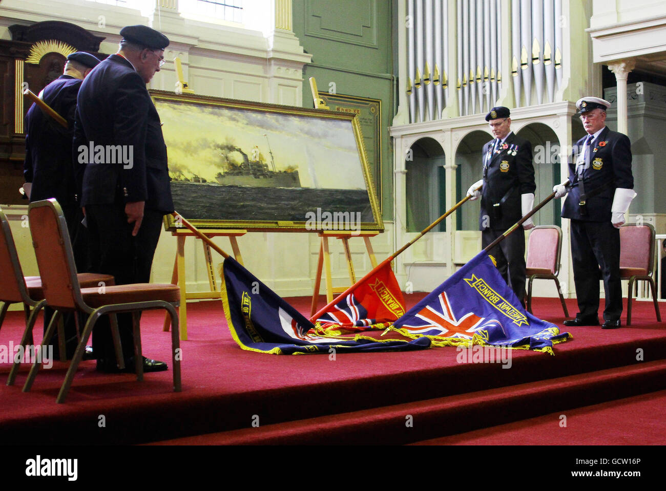 Standard bearers lower their flags during a memorial service held at