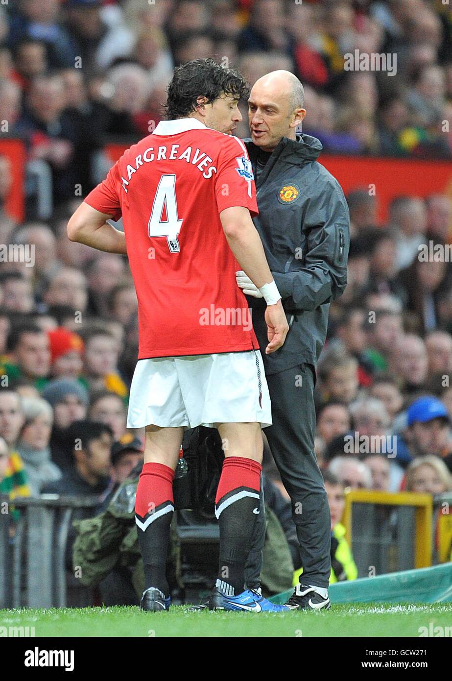 Manchester United's Owen Hargreaves (left) talks to his club's head physiotherapist Rob Swire (right) after suffering an injury only six minutes after starting his first game for Manchester United in two years Stock Photo