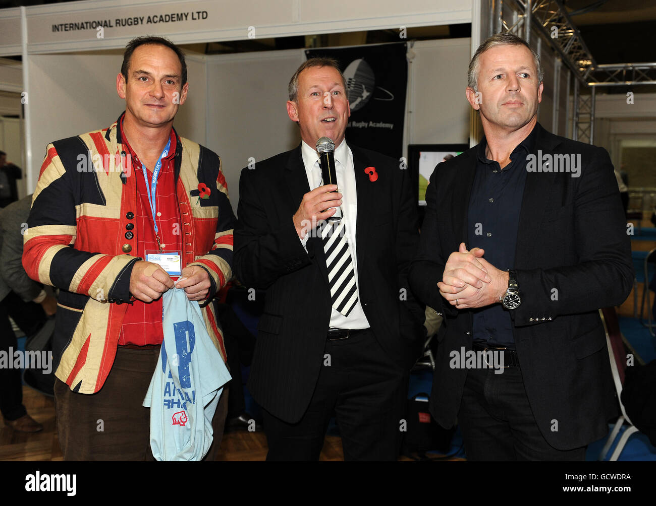 Chief Executive of Rhino Rugby Reg Clark (left) is joined by former All Black rugby star Sean Fitzpatrick (right) in drawing the winner of the Rhino Scrummage Machine during Day Two of the Rugby Expo at the RHS Lawrence Hall, Westminster Stock Photo