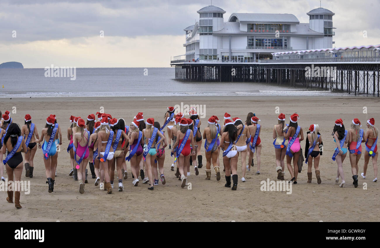 Finalists of the Miss Great Britain beauty pageant walk on the beach beside Weston-super-Mare Pier in -2 degrees C wearing one piece swimsuits. Stock Photo