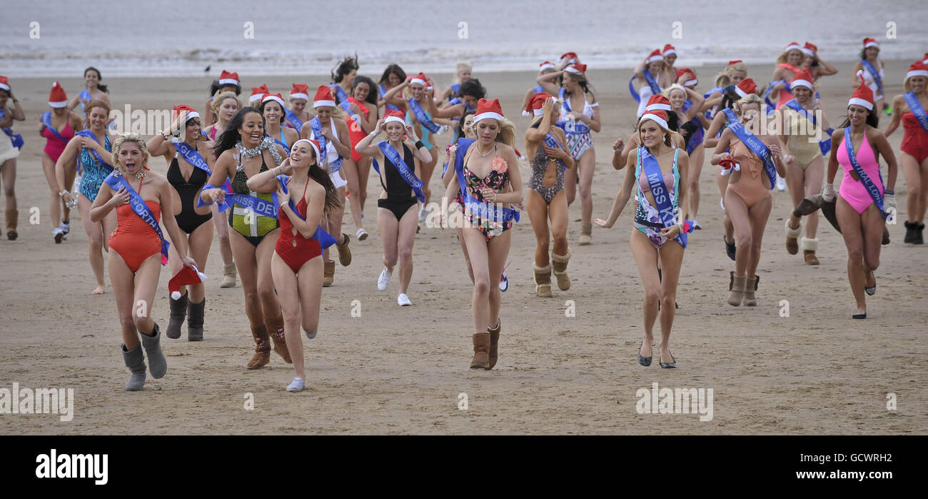 Finalists of the Miss Great Britain beauty pageant run on the beach beside Weston-super-Mare Pier in -2 degrees C wearing one piece swimsuits. Stock Photo