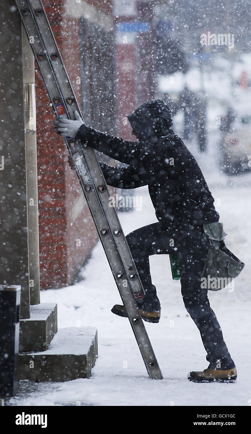 A window cleaner prepares to clean windows in snowy conditions in