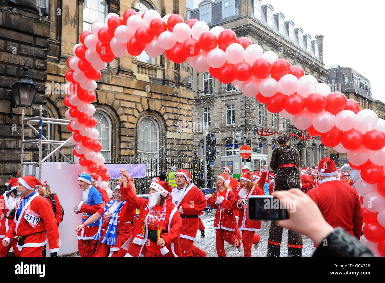 Runners cross the finish line, as ten thousand people dress as Santa to run the annual 5km Liverpool Santa Dash, hoping to take the World Santa Challenge title back from Las Vegas. Stock Photo