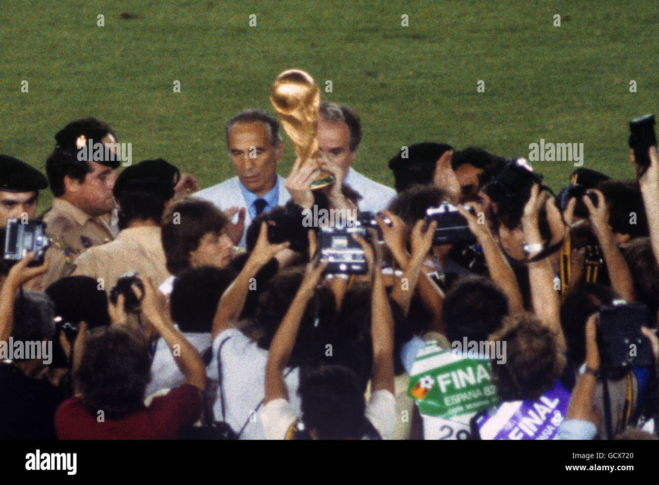 Photographers surround the victorious Italian team who are holding up the World Cup. Coach Enzo Bearzot is pictured to the left of the trophy. Stock Photo