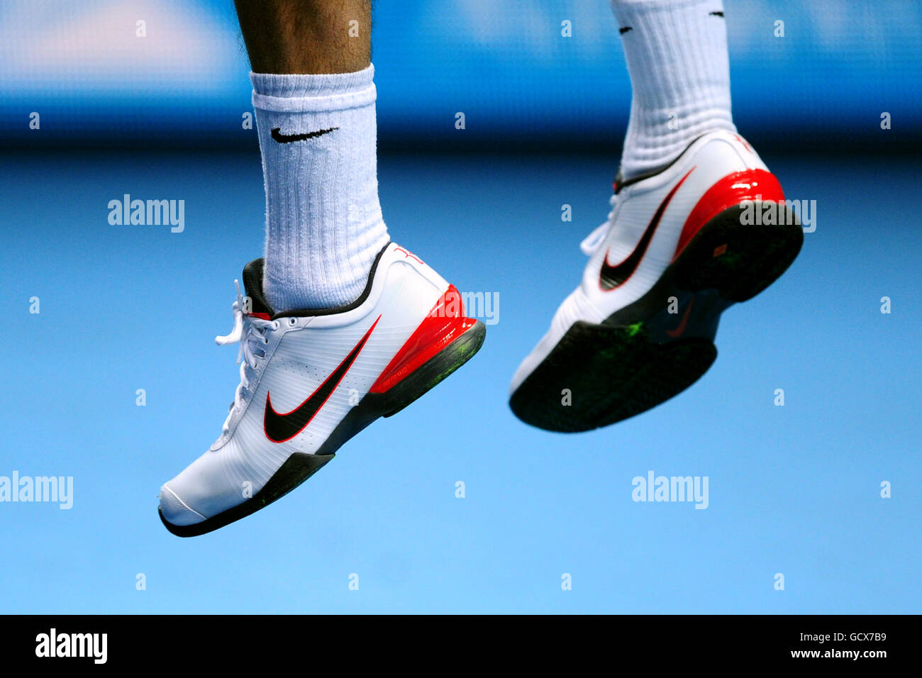 A close up of Roger Federers Nike trainers as he jumps to serve Stock Photo