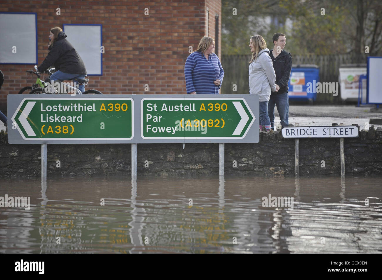 Villagers stand on high ground at the local petrol station St Blazey, Cornwall where flooding has closed the village off and caused havoc. Stock Photo